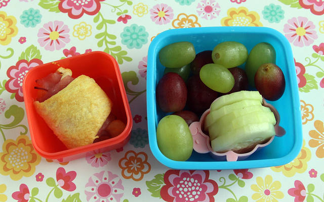 Kindergarten snack with cheesy ham roll, grapes and cukes
