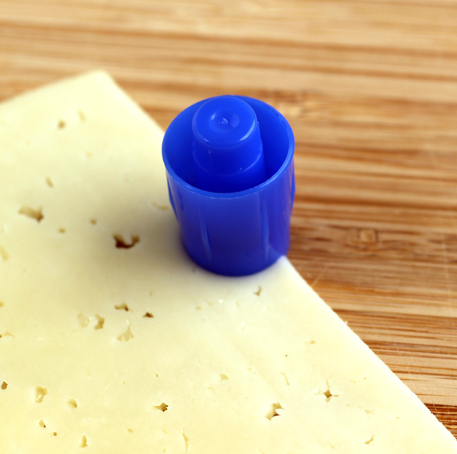 Cut semi-circles from the cheese to use for eyes